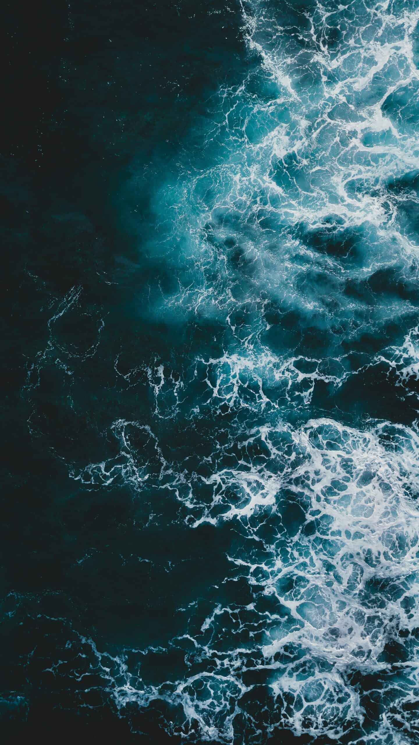 Vibrant ocean waves crashing in deep blue and white foam, creating a dynamic and energetic seascape perfect for water filtration, marine, or aquatic theme visuals.